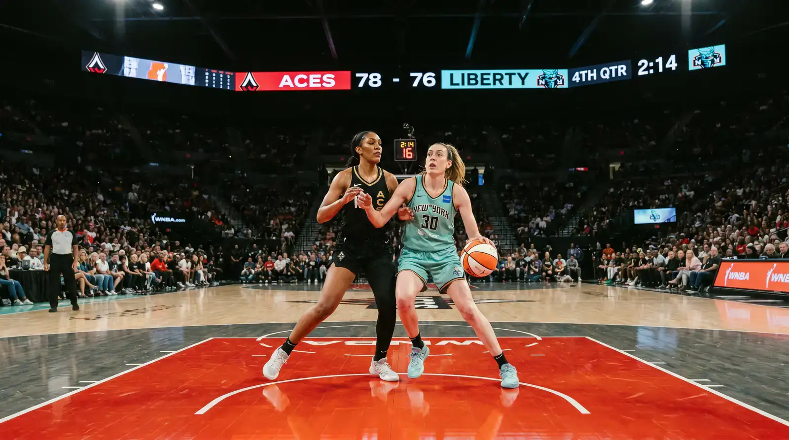 Partido de la WNBA con grada llena y pantalla de marcador electronico